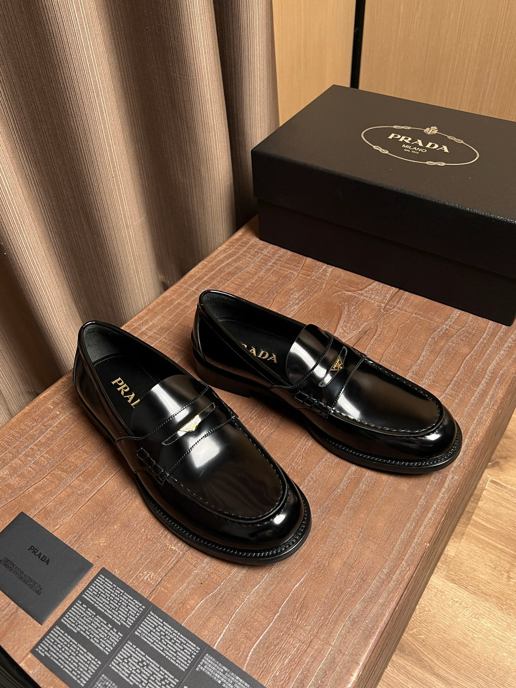 Black patent leather loafer pair with gold bar buckle detail