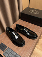Black patent leather loafer pair with gold bar buckle detail