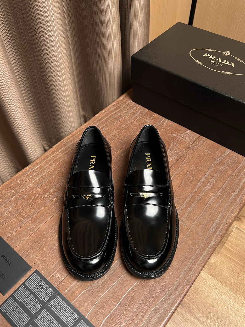 Black patent leather loafer with gold buckle strap, unisex