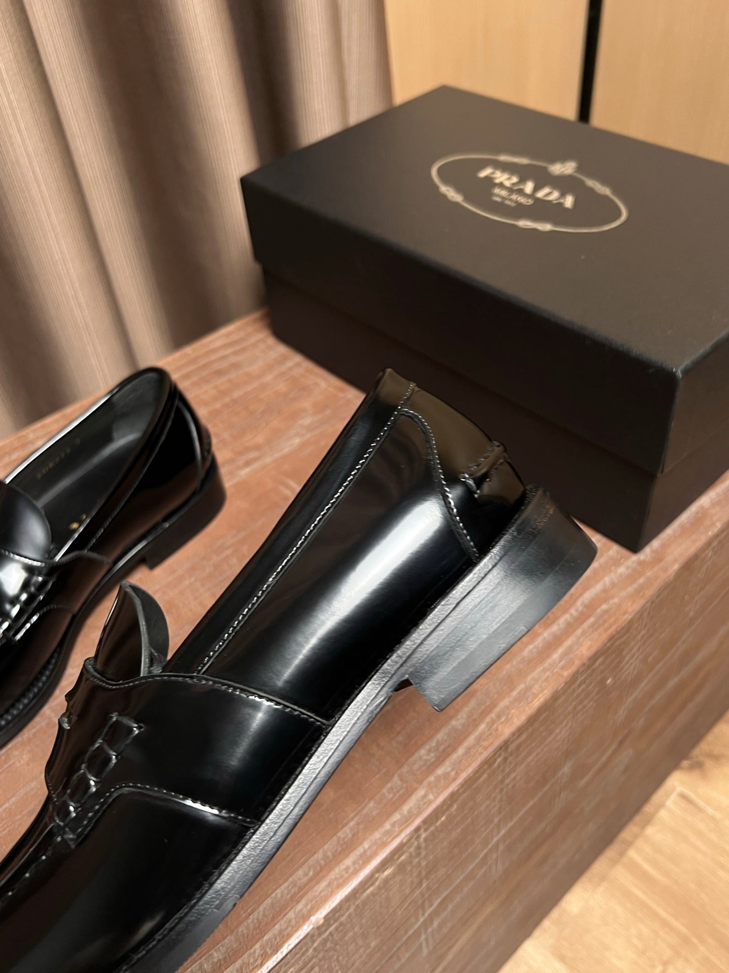 Black leather Prada loafer, side profile with metal strap detail