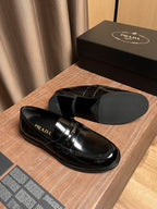 Black patent leather loafer with gold buckle strap, side profile view