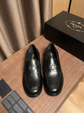 Black leather Prada loafers with gold logo trim and stitched apron