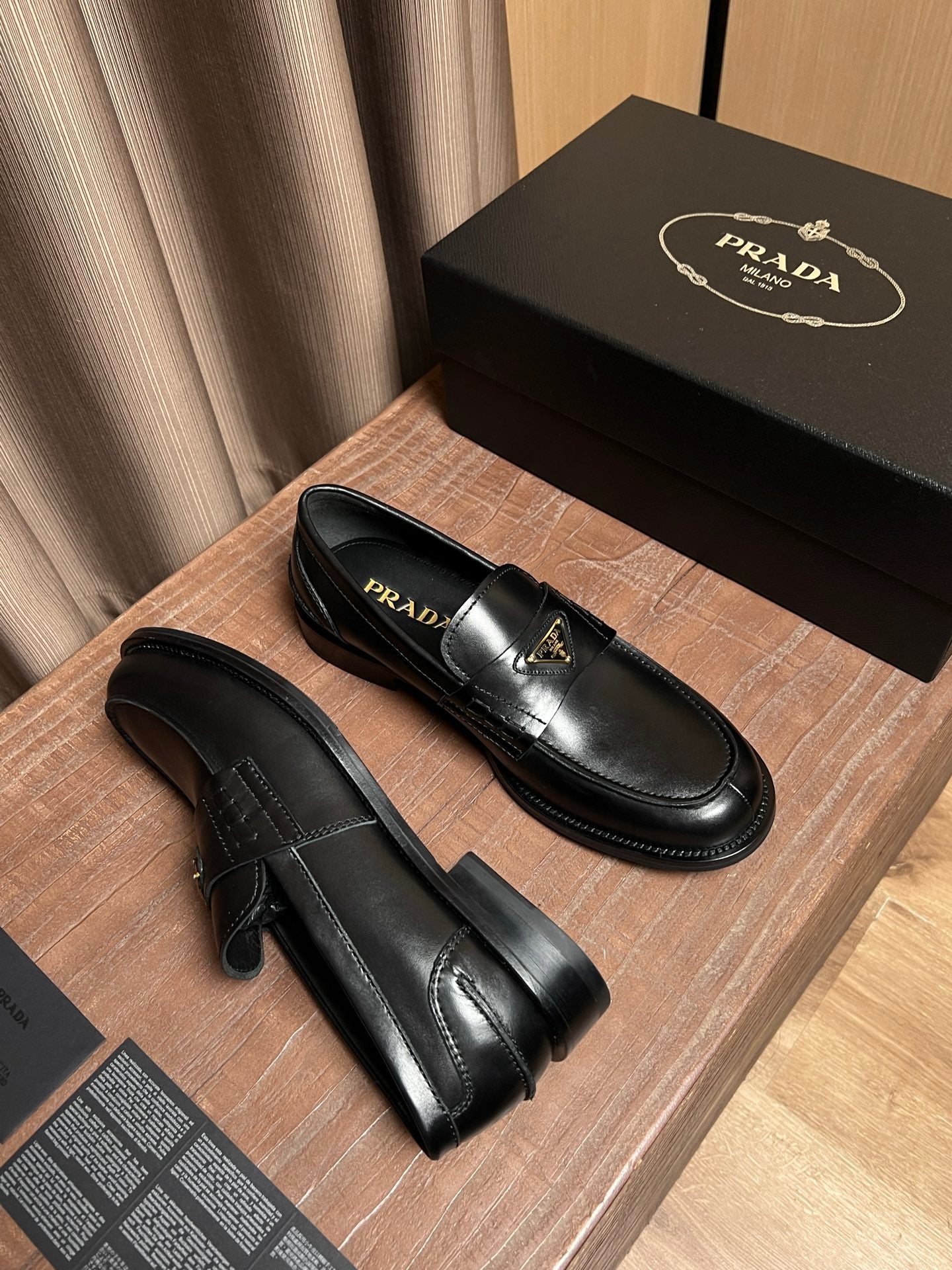 Black leather Prada loafers, side view with stitched detailing and chunky sole
