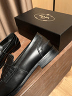 Black leather Prada loafer with squared toe, side seam stitching, black sole