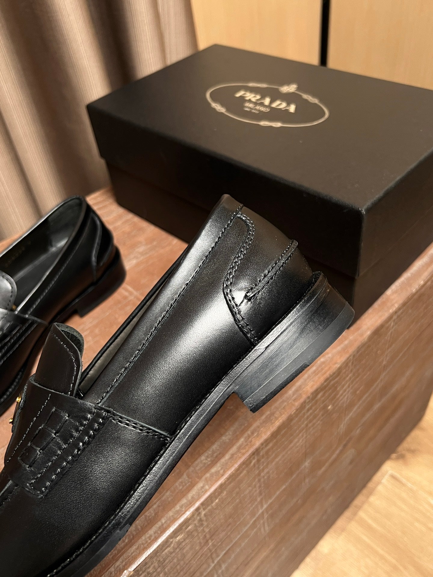 Black leather Prada loafer with squared toe, side seam stitching, black sole