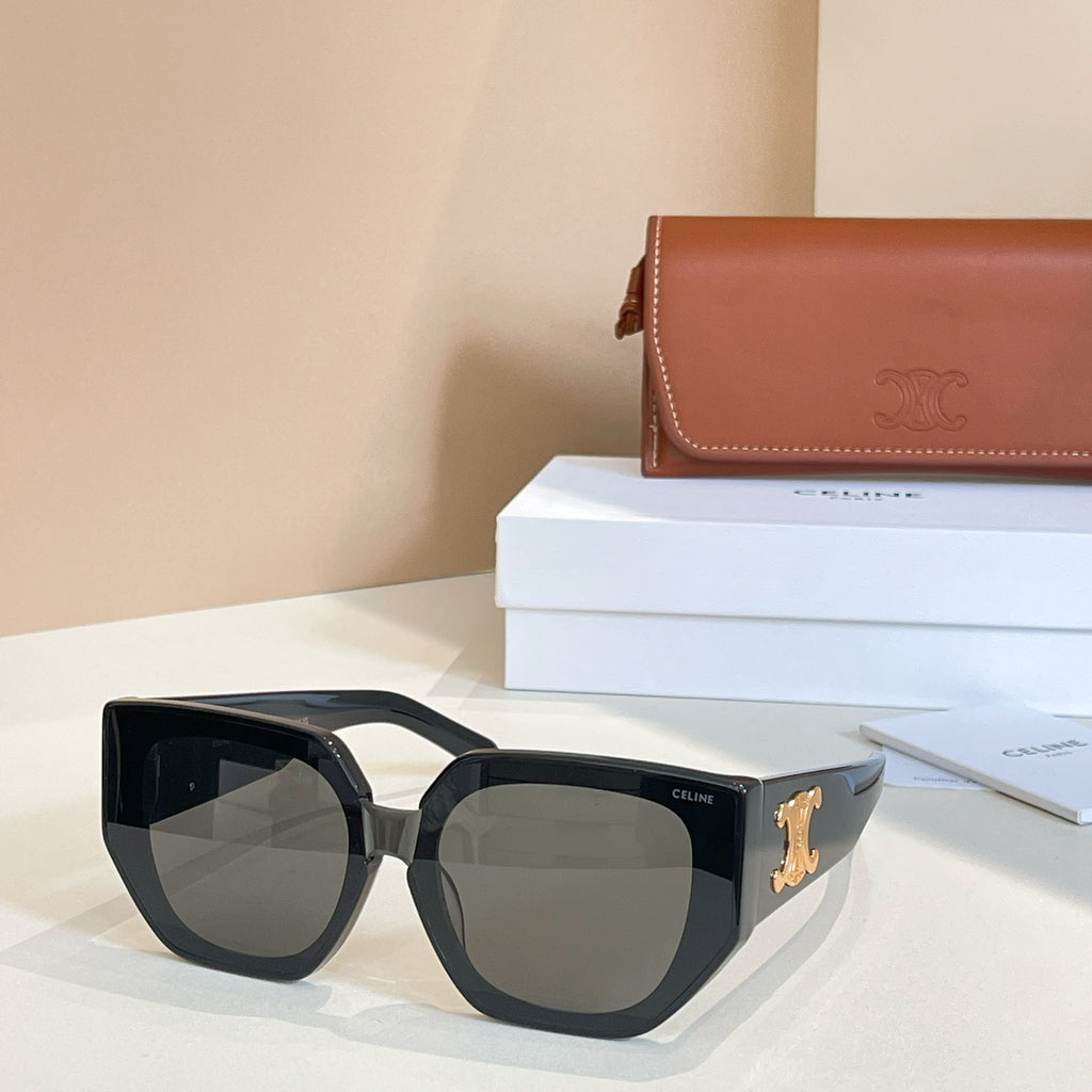 Black sunglasses with gradient amber lenses and gold logo on the temple