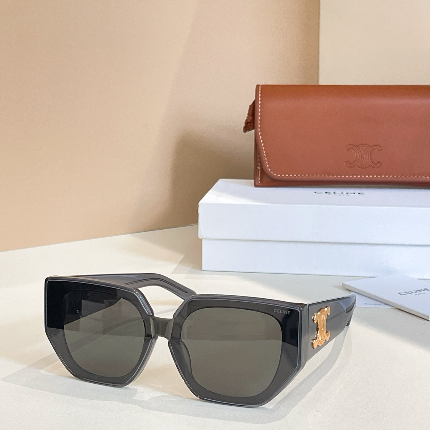 Black sunglasses with dark lenses and gold logo on the outer temple