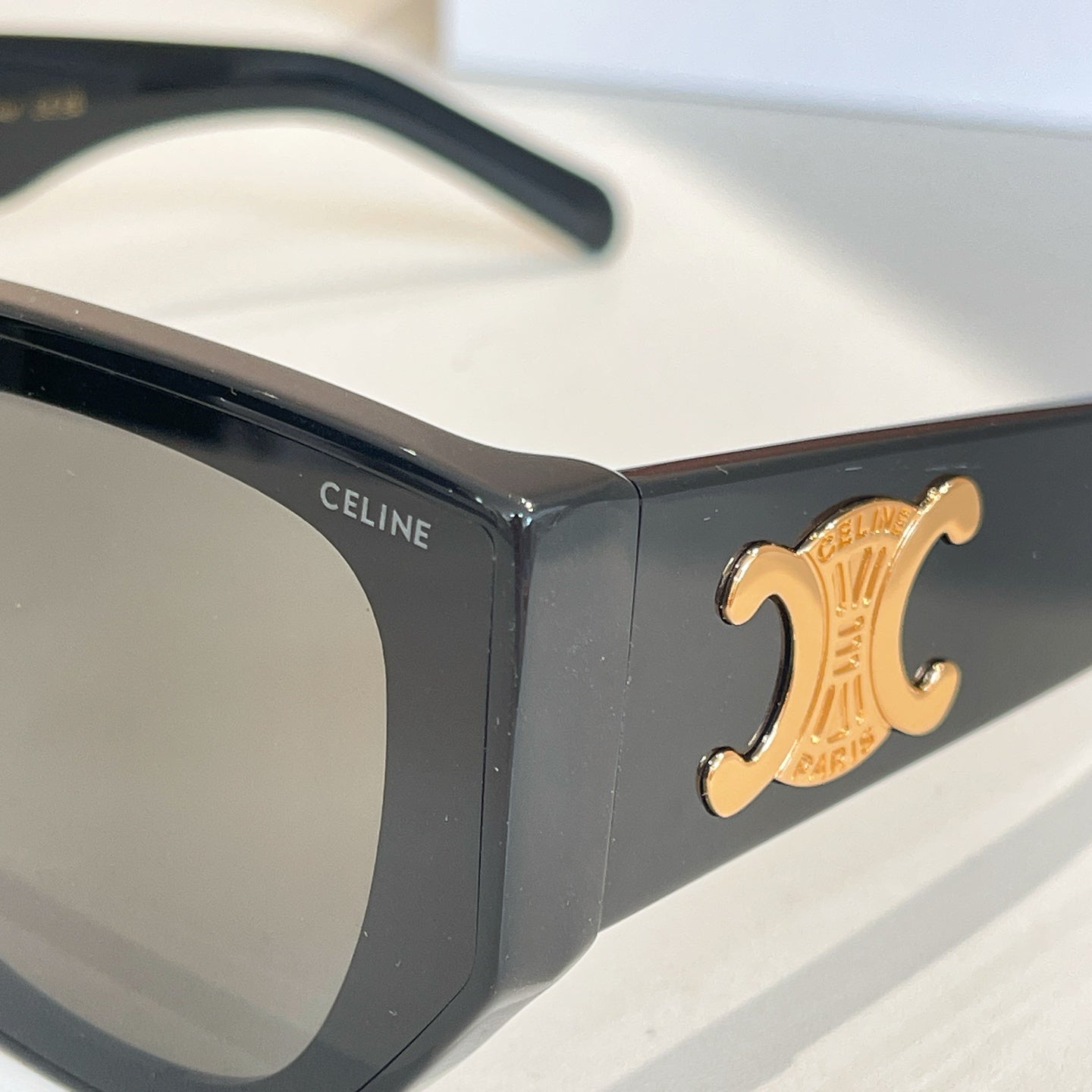 Black sunglasses close-up with gold emblem and CELINE text on the frame