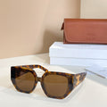 Tortoiseshell sunglasses with dark lenses and gold logo detail on the temple
