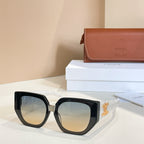 Black sunglasses with amber-tinted lenses and gold logo temple detail