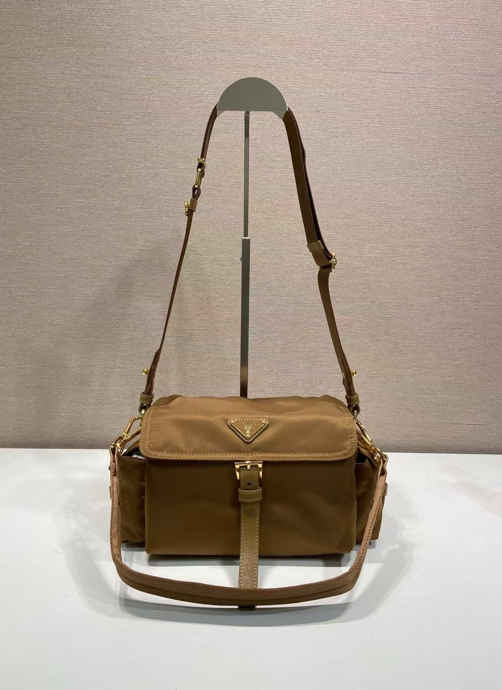 Prada crossbody bag in tan with flap, top handle strap and gold hardware