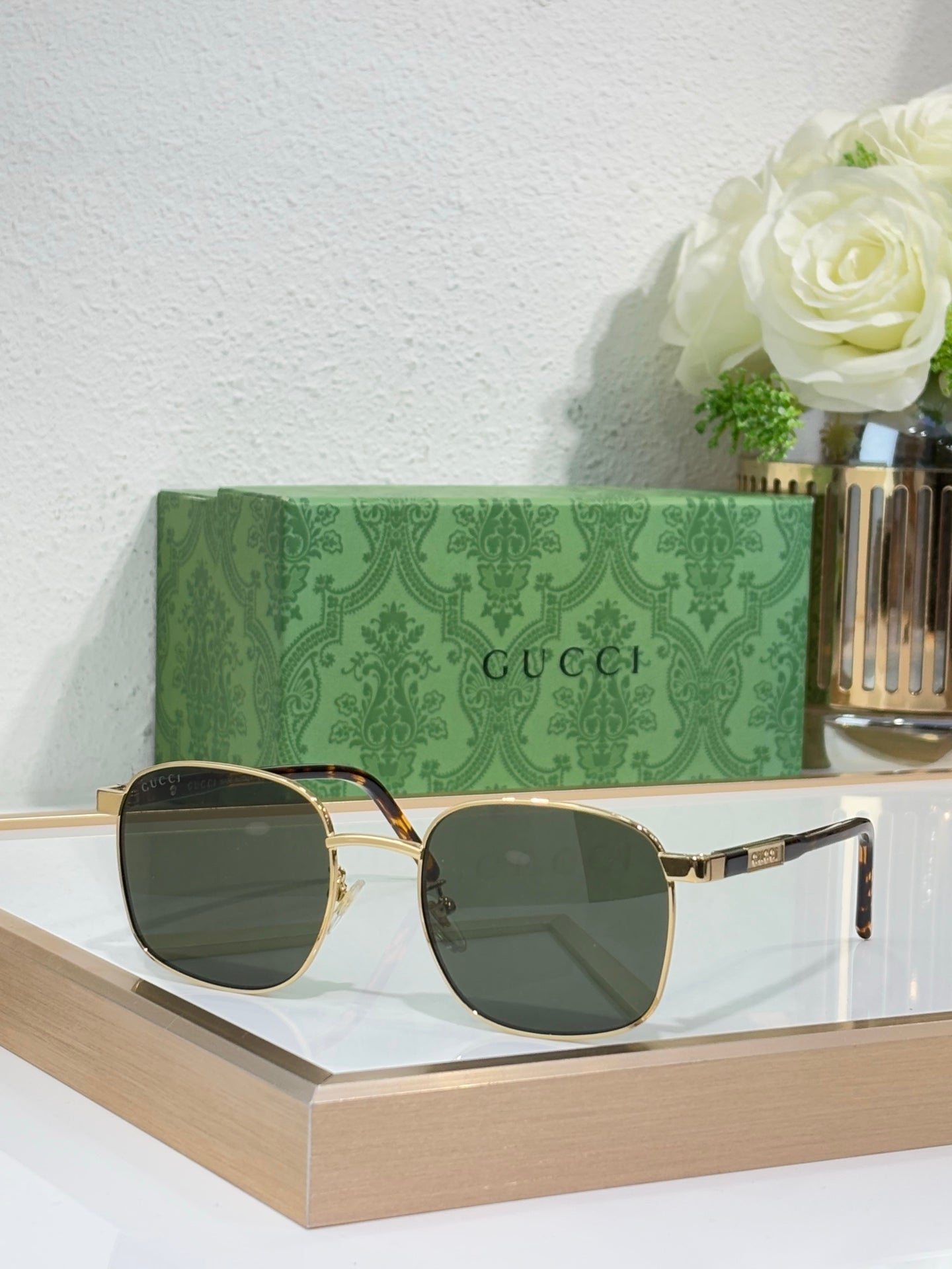 Gucci sunglasses with dark lenses and black frame with gold accents