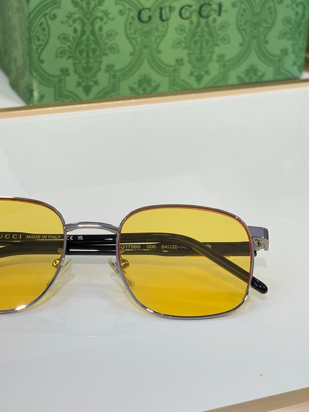 Gucci sunglasses close-up with yellow lenses and gold metal bridge