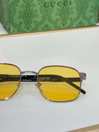 Gucci sunglasses close-up with yellow lenses and gold metal bridge