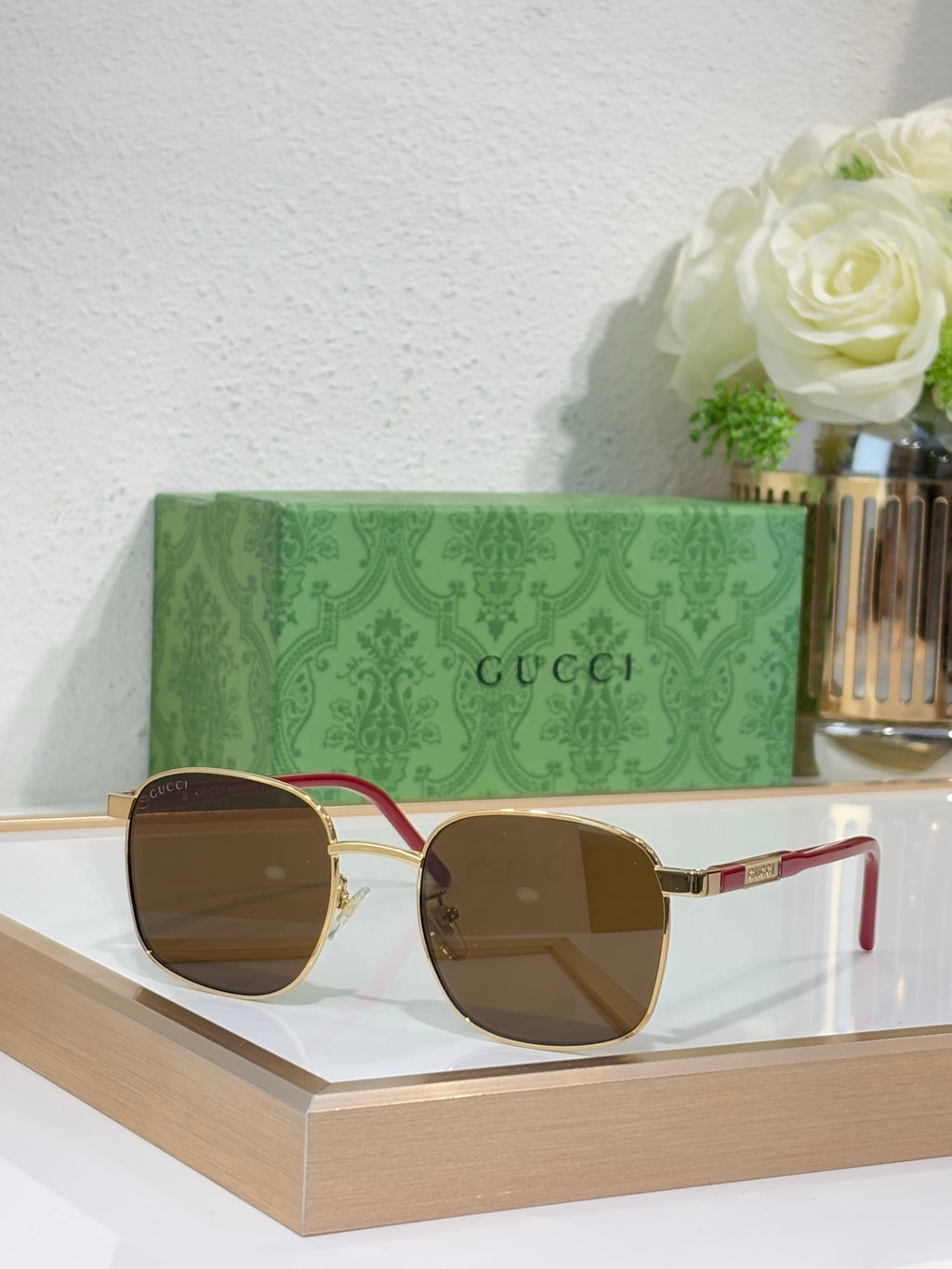 Gucci sunglasses with brown lenses and red-accent metal frame