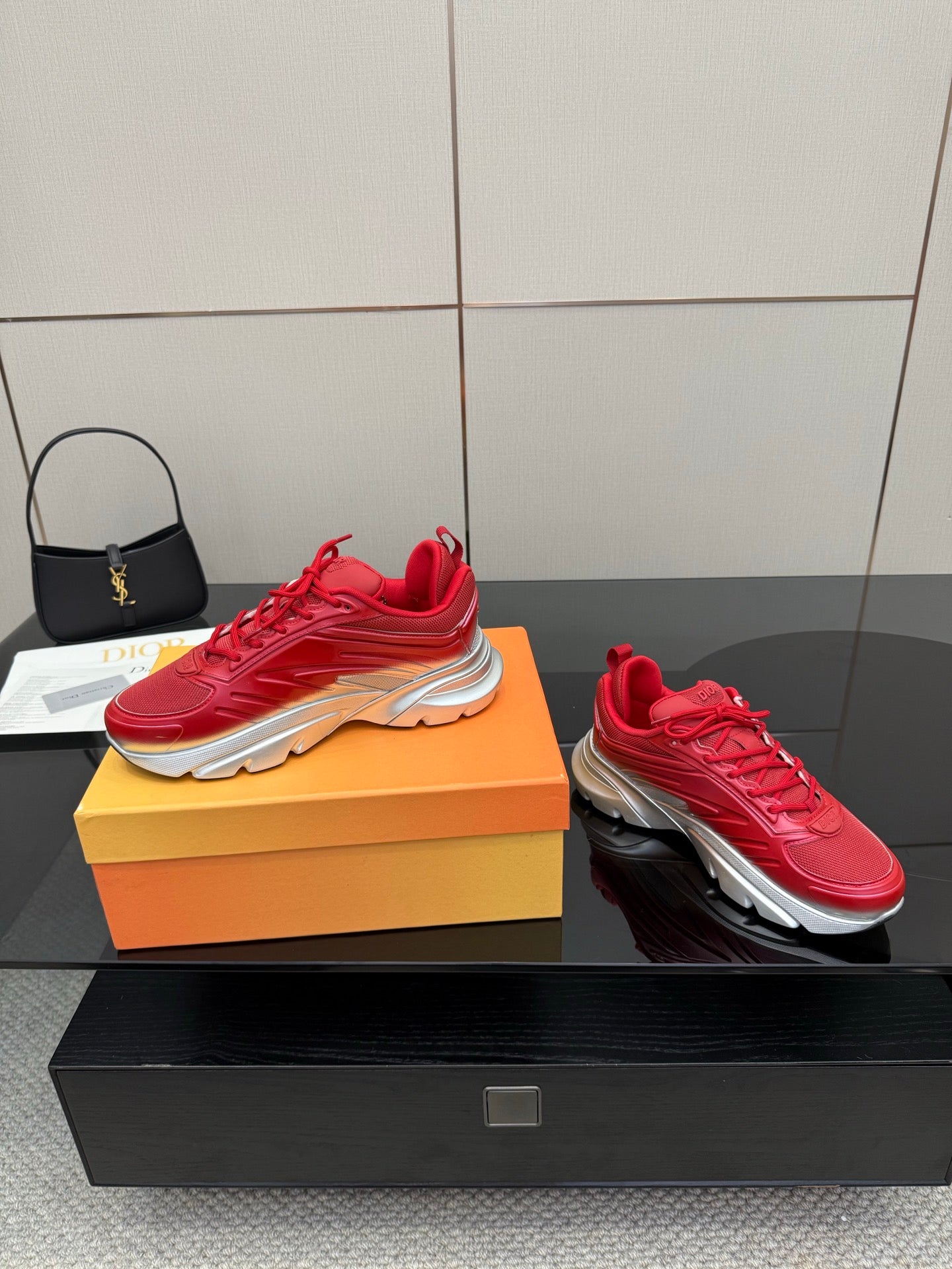 Red lace-up sneakers with chunky sole on an orange shoebox