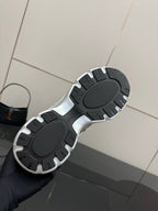 Sneaker outsole view with dark tread pattern and silver trim edges