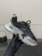 Ladies' Dior sneaker held up, black and silver colorblocked design with laces