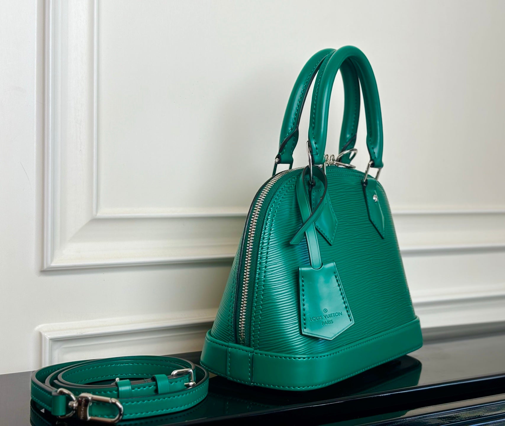 Louis Vuitton green handbag with front zipper, top handles, and detachable strap