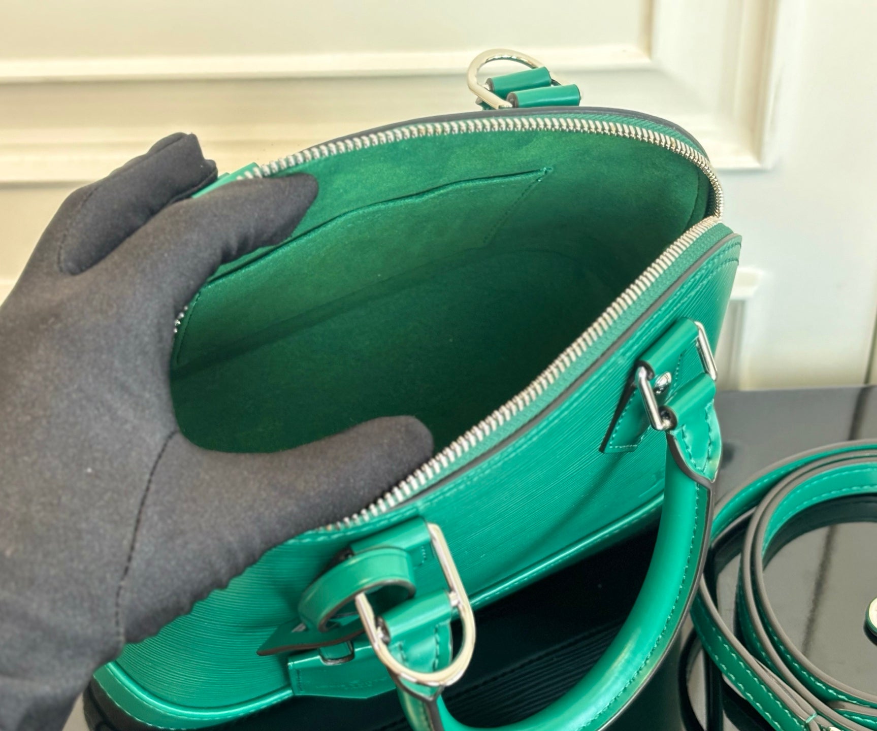 Louis Vuitton green handbag interior view with zipper opening and silver-tone rings