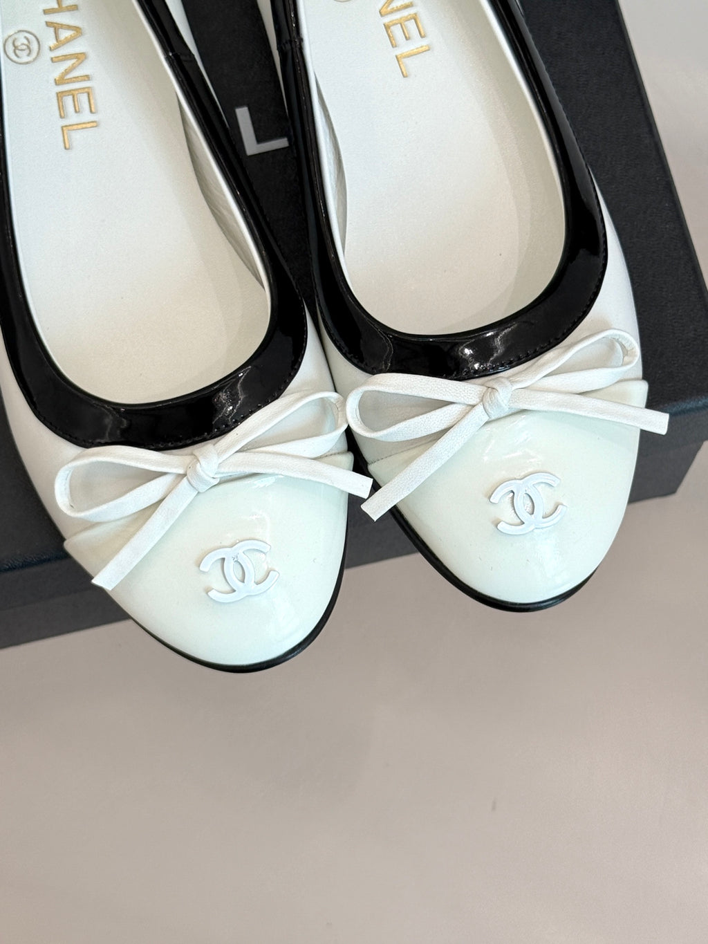 White ballet flats with black patent trim and bow, Chanel logo