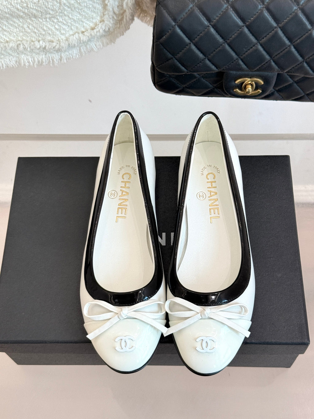 White ballet flats with black piping and lace-up bow, Chanel