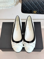 White ballet flats with black piping and lace-up bow, Chanel