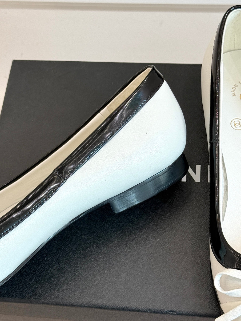 White leather ballet flat with black heel edge and grosgrain trim