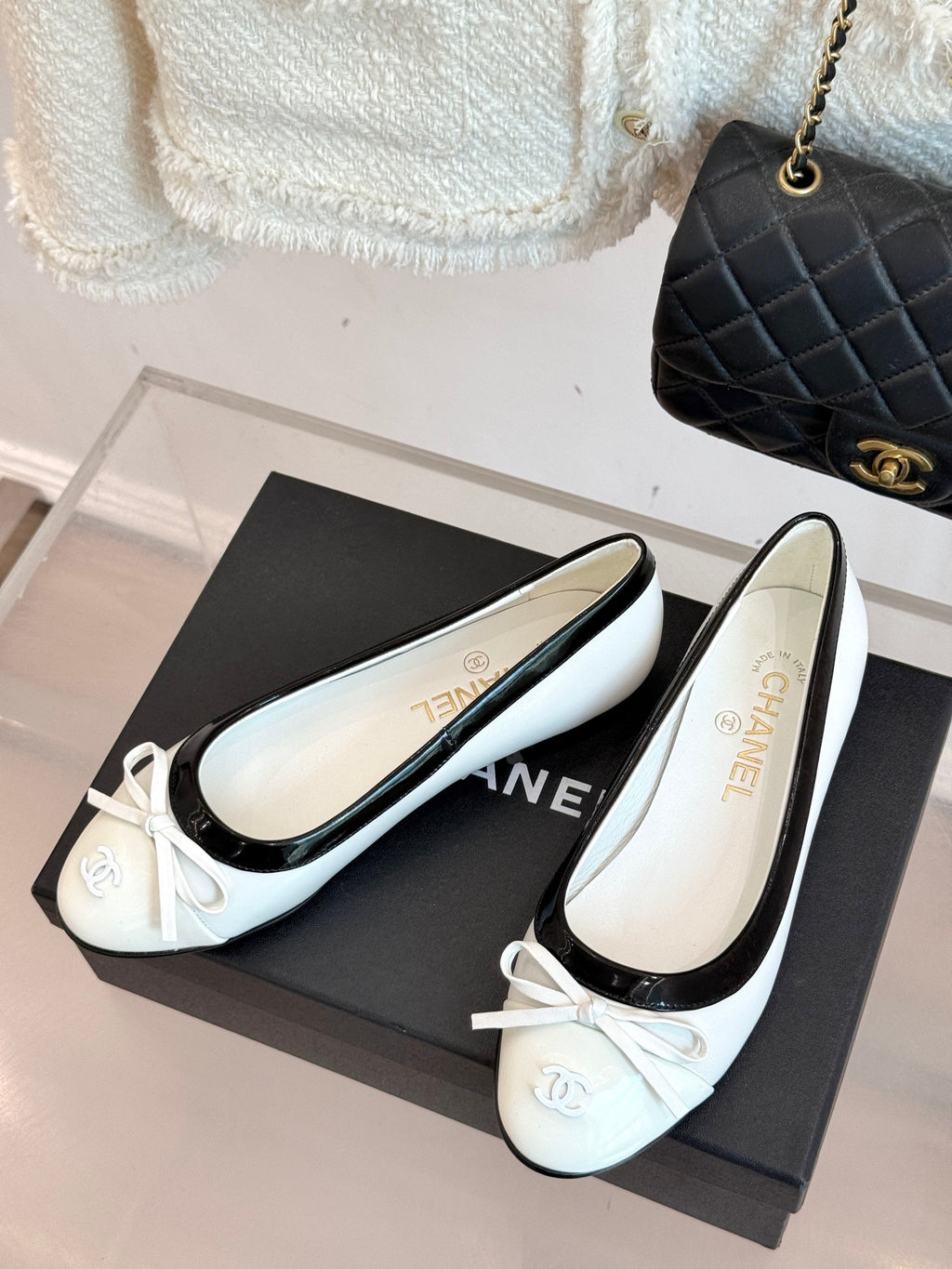 White ballet flats with black patent edging and bow on box