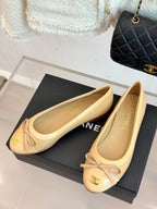 Beige ballet flats with bow detail, gold CC logo, pointed toe