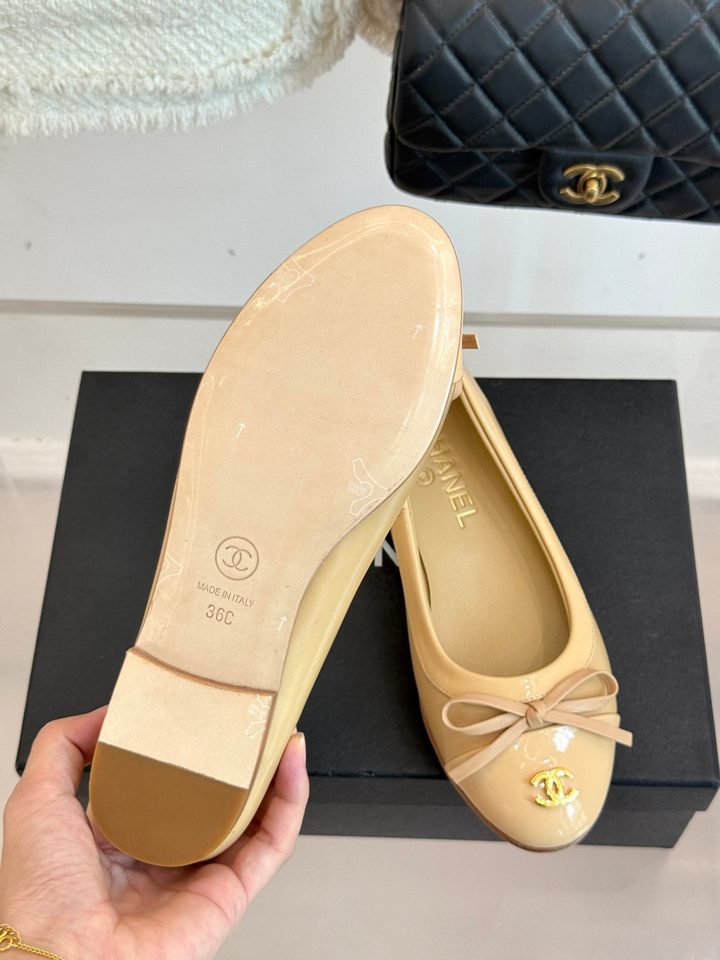 Beige ballet flat sole and interior with CHANEL logo, held in hand