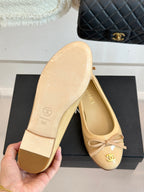 Beige ballet flat sole and interior with CHANEL logo, held in hand
