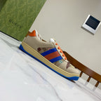 Gucci unisex low-top sneakers, side view with orange laces and blue-red web stripe