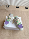 Pair of low-top sneakers with purple toe panel and green lace accents, Dior branding.