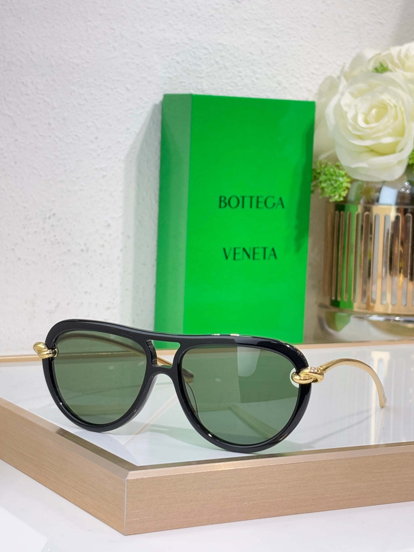 Bottega Veneta sunglasses with black frame and green tinted lenses