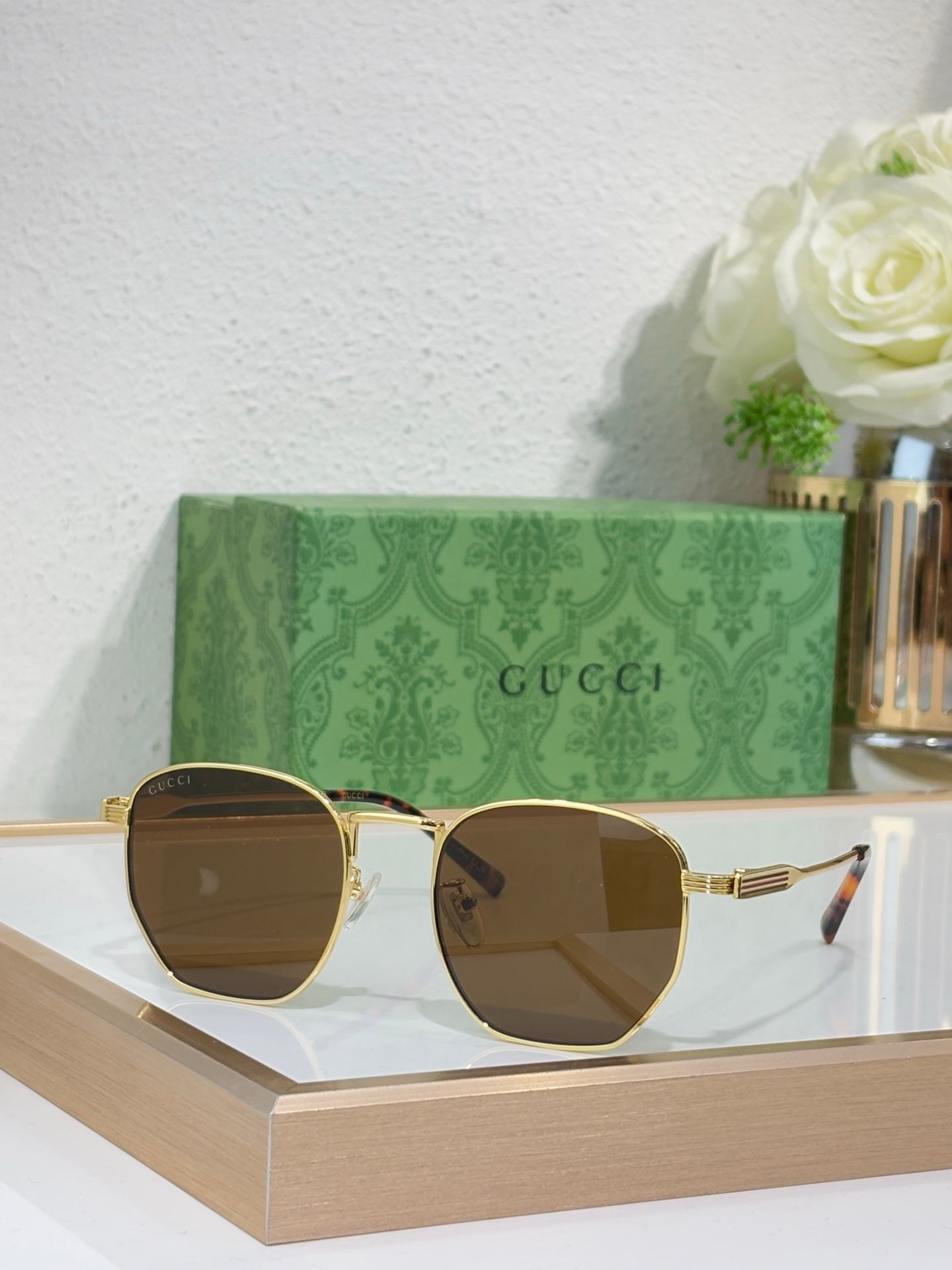 Gucci gold round-frame sunglasses with brown-tinted lenses and ribbed temples
