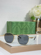 Gucci gold round sunglasses with dark lenses, gold bridge, and ribbed temple arms