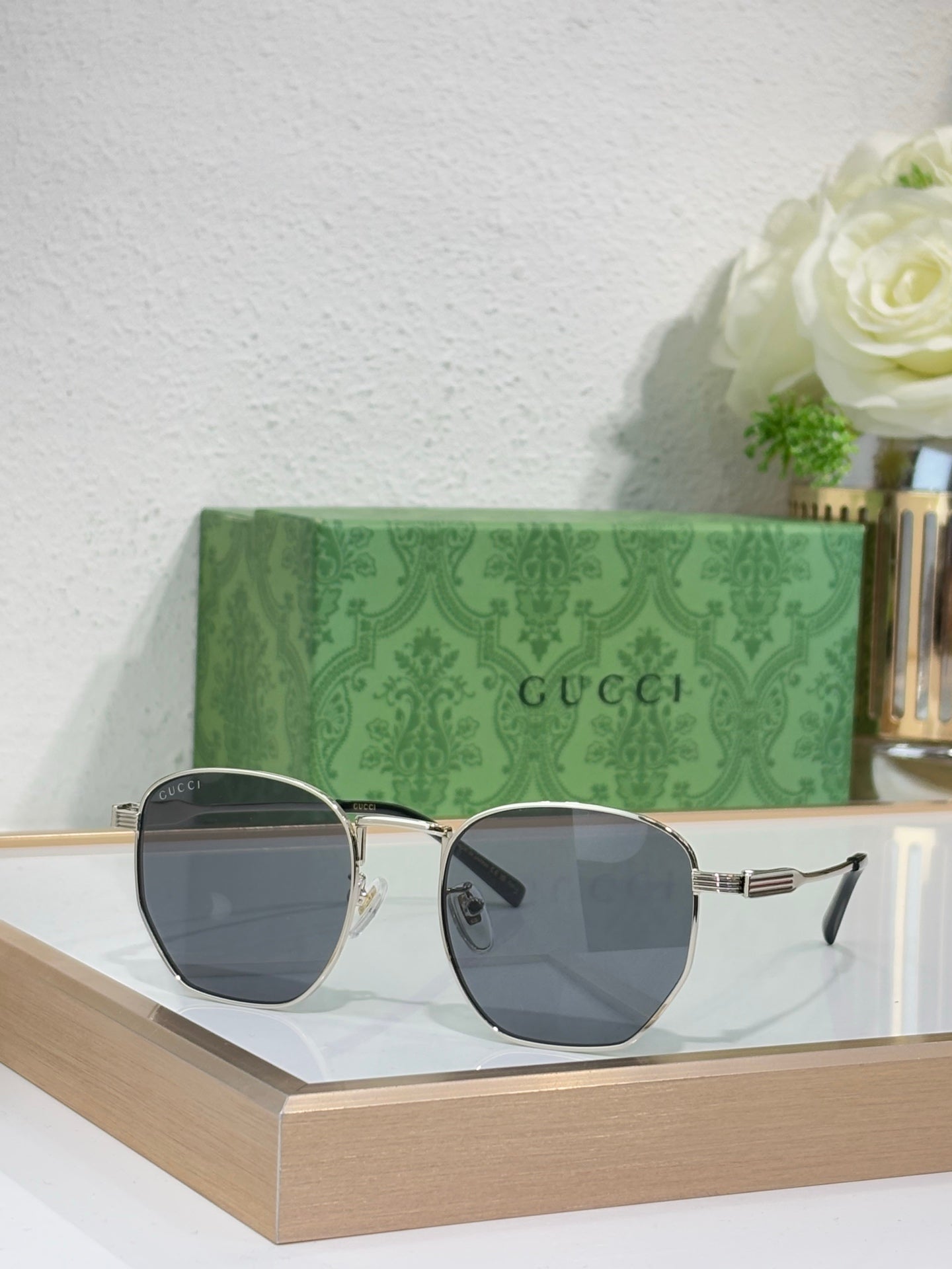 Gucci gold round-frame sunglasses with dark gray lenses and metal temple details