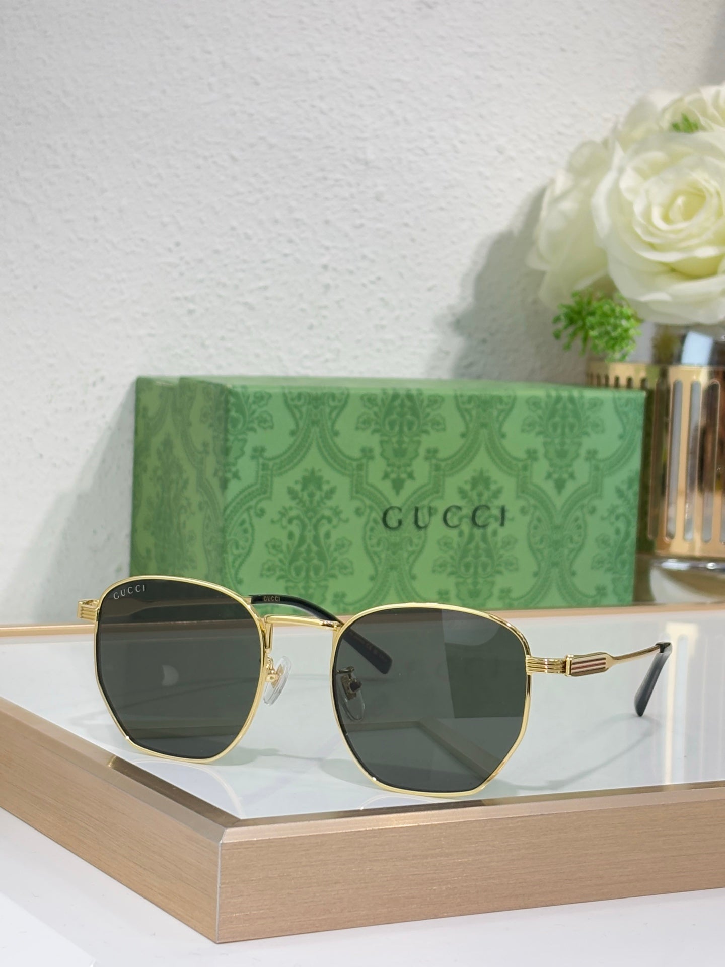 Gucci gold round-frame sunglasses with dark lenses and curved metal ear pieces