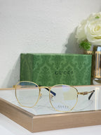 Gucci gold round-frame glasses with clear lenses and GUCCI logo on lens