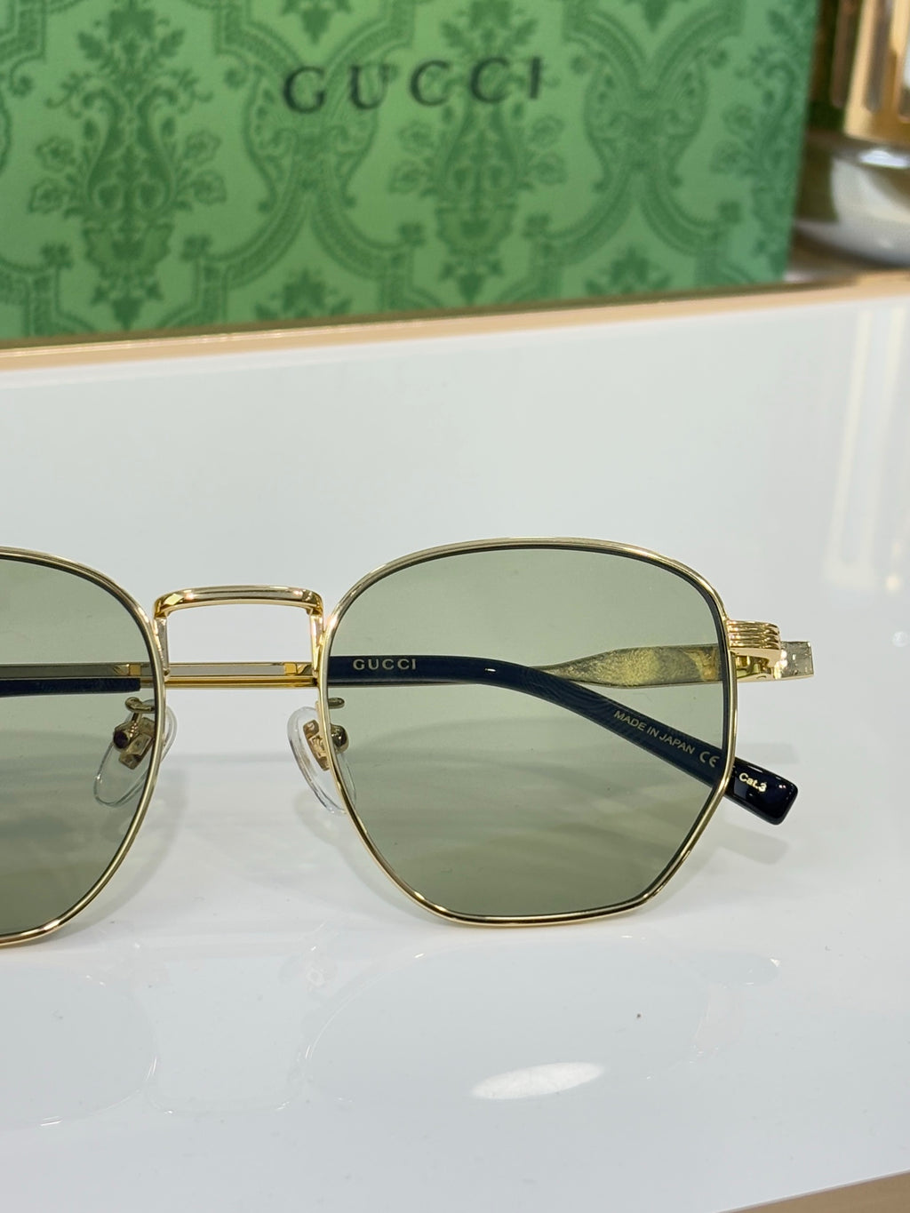 Gucci eyeglasses with gold rims and dark lenses, angled side view