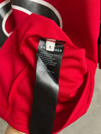 Red jersey fabric close-up with inner neck label and size tag on garment