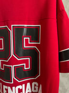Red jersey back side close-up with black-outlined number 5 patch and BALENCIAGA