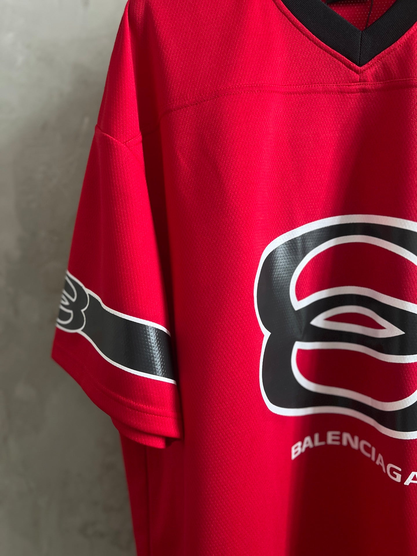 Red short-sleeve V-neck sweatshirt with oversized logo on front