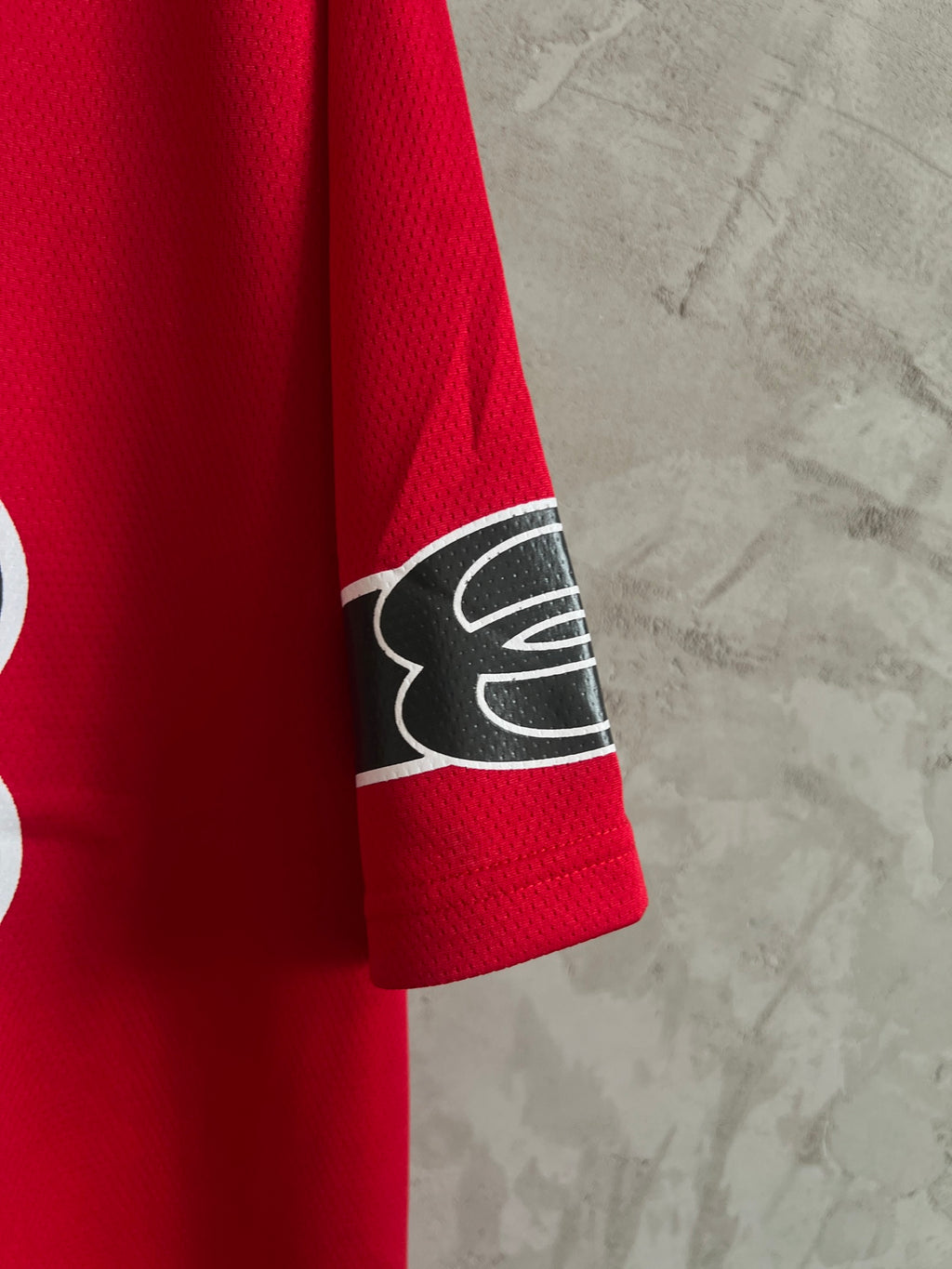 Red short-sleeve sweatshirt with black logo patch on sleeve cuff