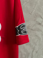 Red short-sleeve sweatshirt with black logo patch on sleeve cuff