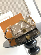 Designer shoulder bag with gray monogram canvas, gold chain strap, flap and clasp.