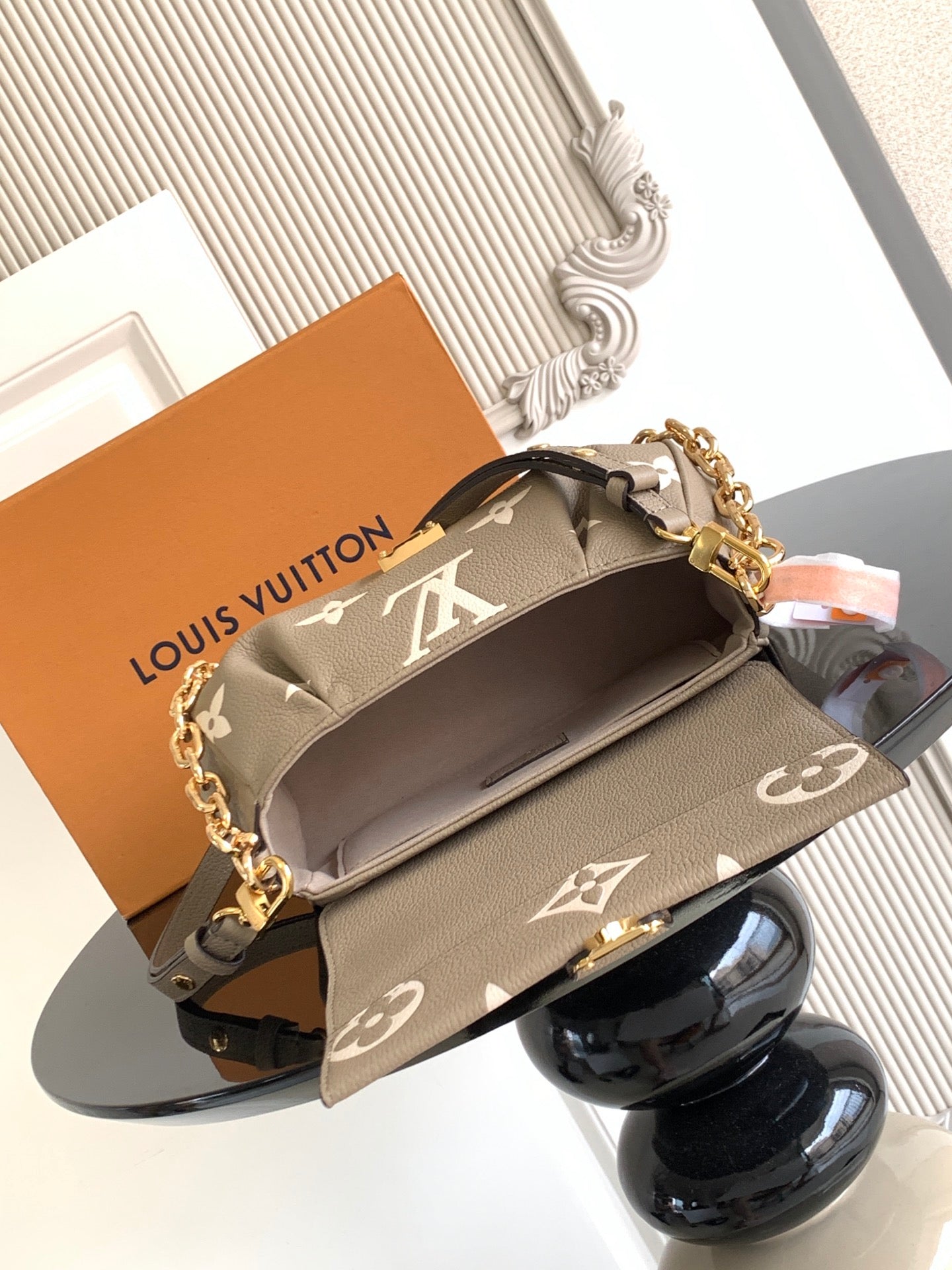 Gray monogram crossbody bag with gold chain strap, front flap, and interior top opening.
