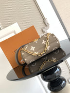Designer crossbody bag in gray monogram canvas with gold chain strap and flap closure.