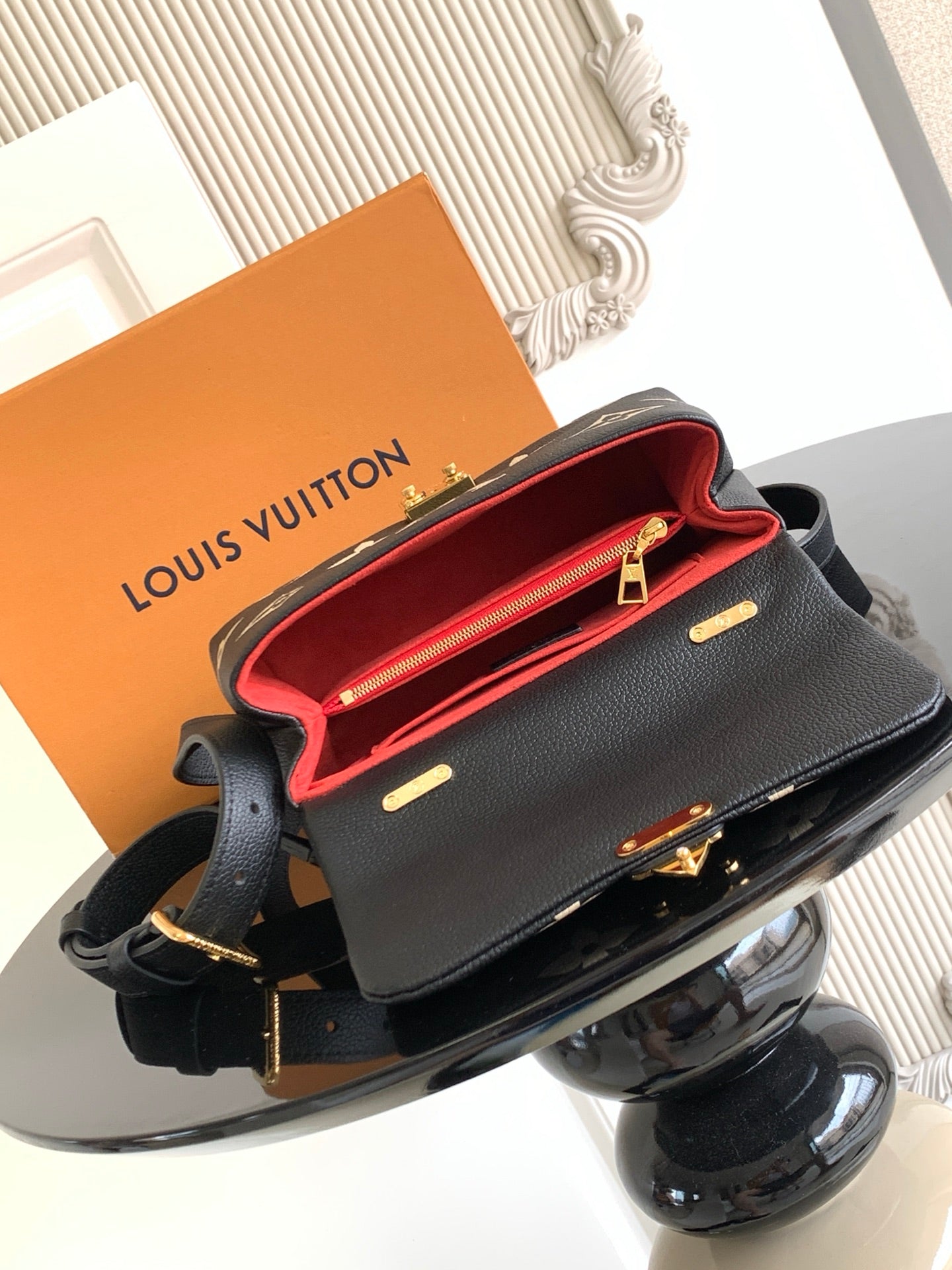 Louis Vuitton monogram mini bag open showing red interior, gold hardware on black